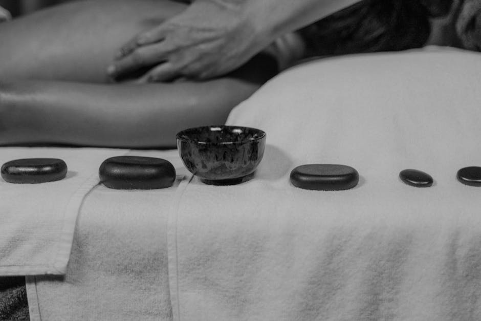 Hot stone massage therapy with smooth basalt stones arranged on back